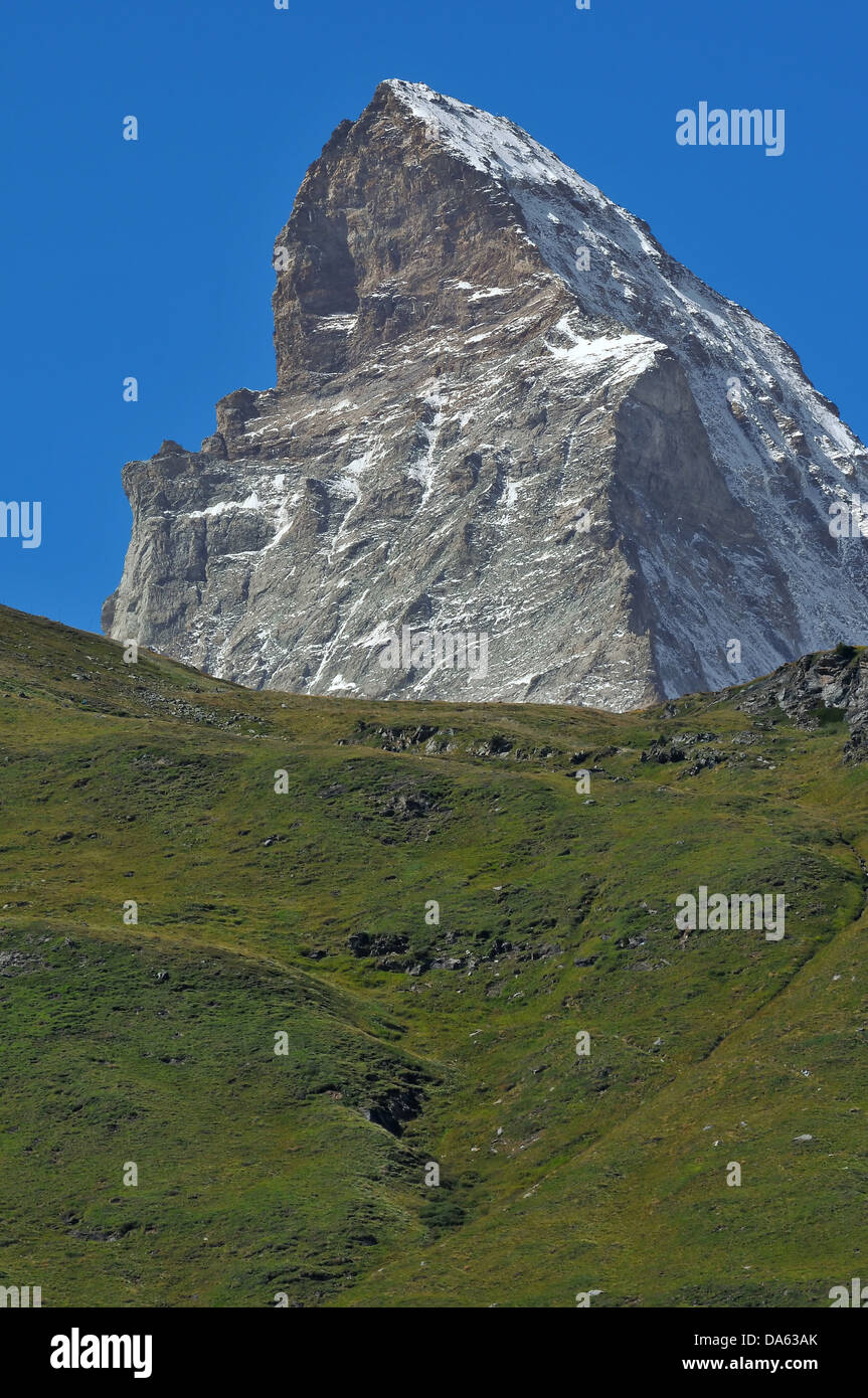 L'imperioso Cervino nelle alpi svizzere al di sopra di Zermatt. In primo piano estate erba sulle colline Foto Stock
