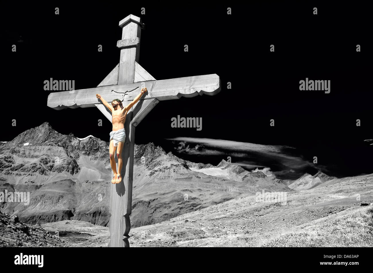 Stordimento e drammatica monocromatica ottimizzata croce con Gesù Cristo crocifisso, in montagna, al di sopra di un lago, con alte alpi in t Foto Stock
