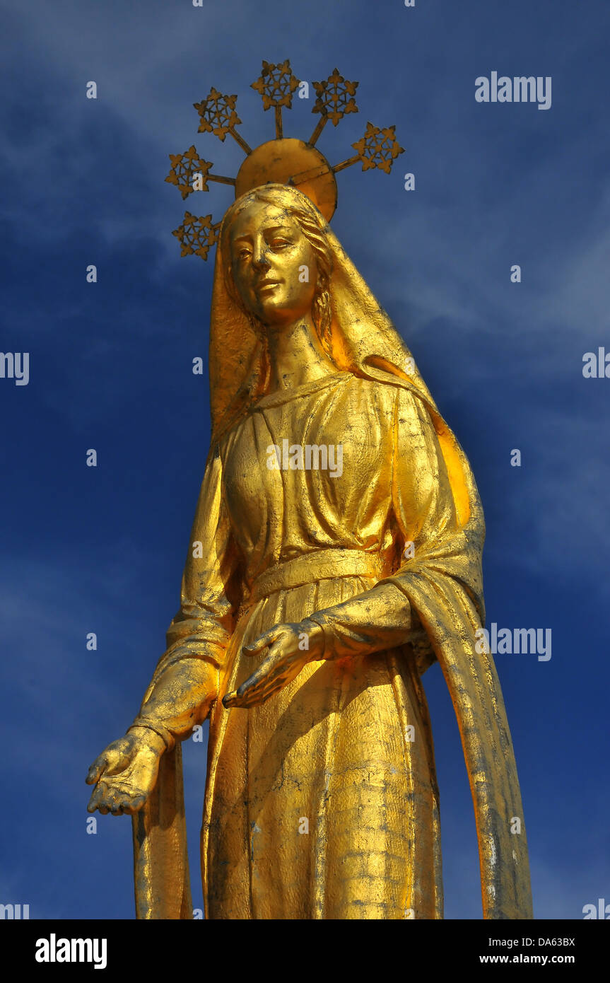 Oro bella statua della Vergine Maria in piedi sulla parte superiore di un antico passano tra Italia e Svizzera. l'alone containi Foto Stock