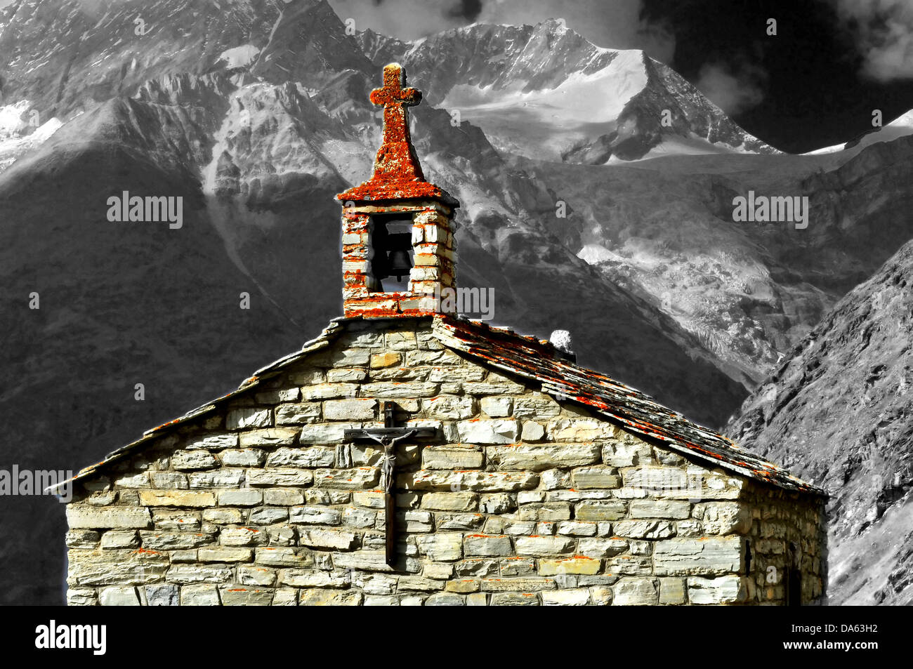 Una vecchia cappella in montagna, con una piccola torre campanaria e montagne sullo sfondo, il Weisshorn, Foto Stock