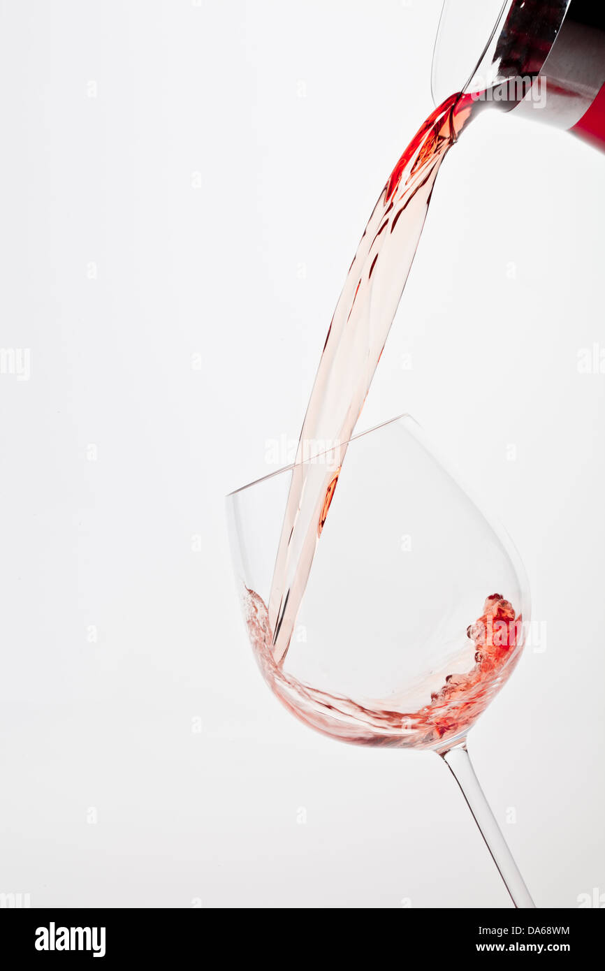 Versare il vino nel bicchiere, alcol schizzi Foto Stock