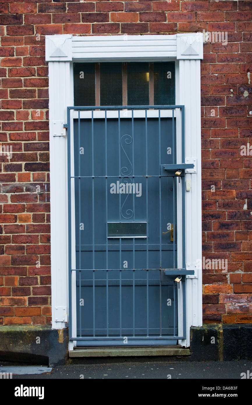 Grigia porta dell'edificio con bloccato cancello di sicurezza in Leeds West Yorkshire England Regno Unito Foto Stock