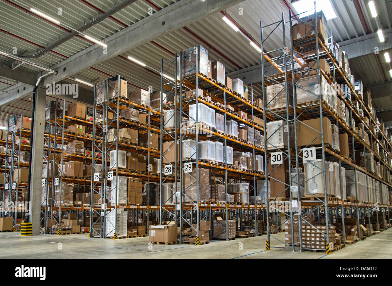Un magazzino moderno con molti ripiani alti. Tutti i loghi e i marchi registrati sono stati rimossi. Foto Stock