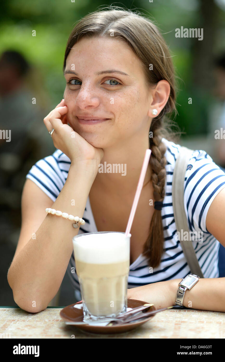 Giovane donna con un latte macchiato Foto Stock