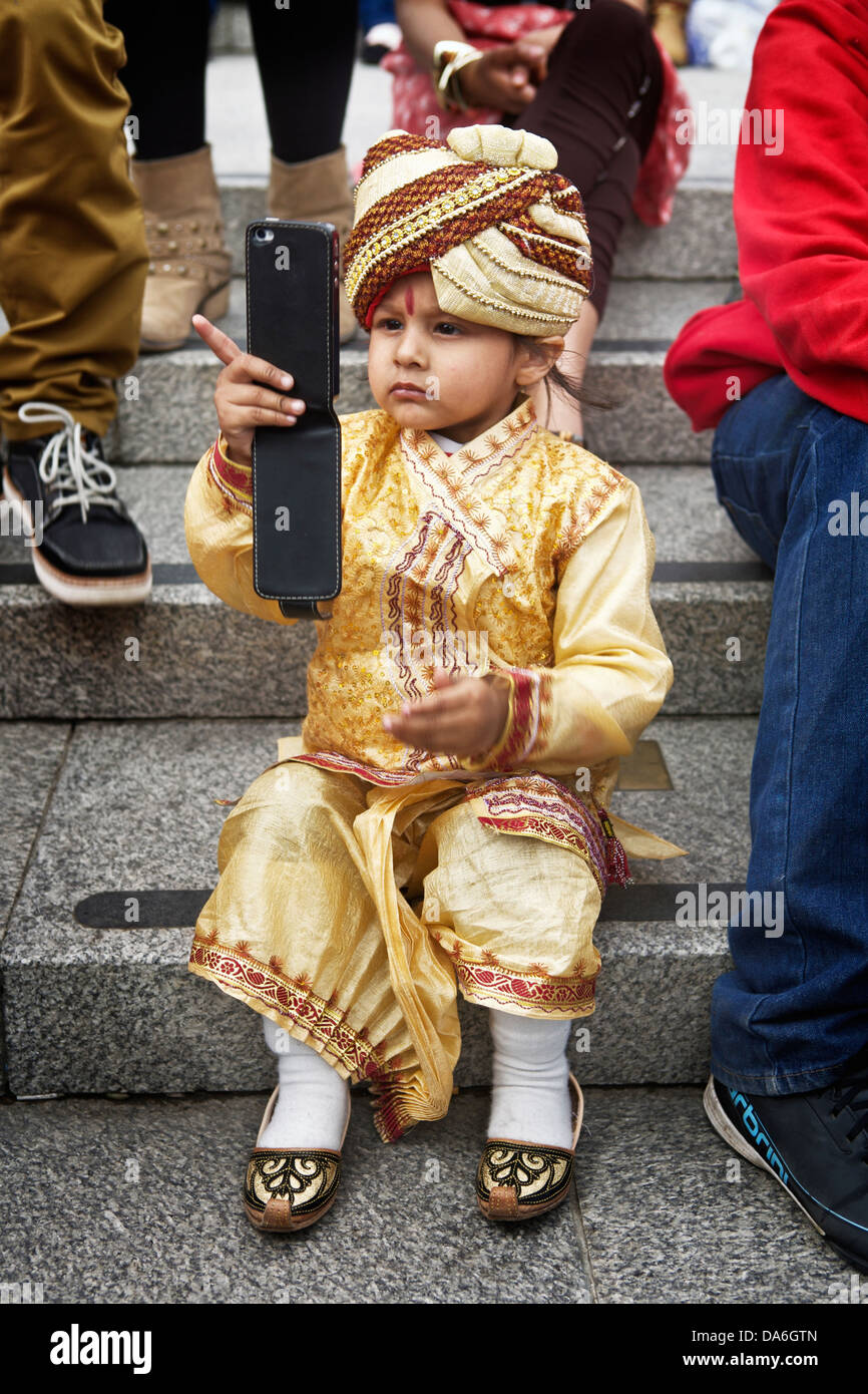 Ritratto di un giovane ragazzo seduto su passaggi utilizzando un telefono cellulare. Foto Stock