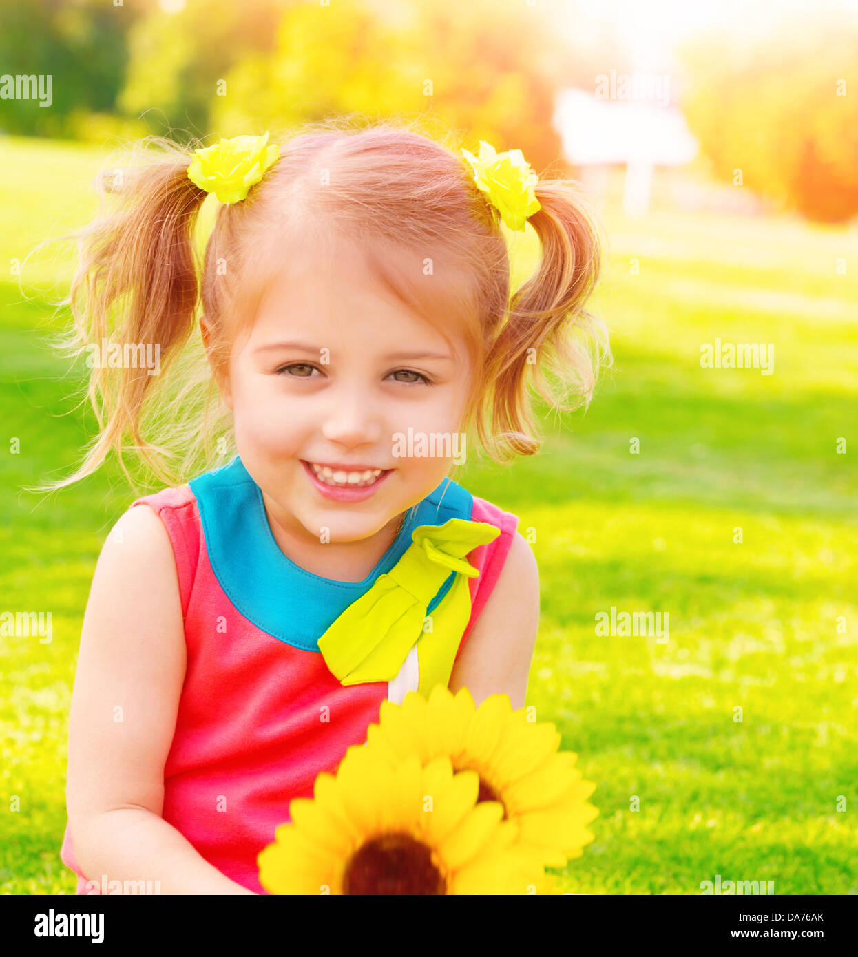 Adorabili dolce bambino con girasoli bouquet divertirsi nel giardino, bambina godendo estate natura, il concetto di felicità Foto Stock