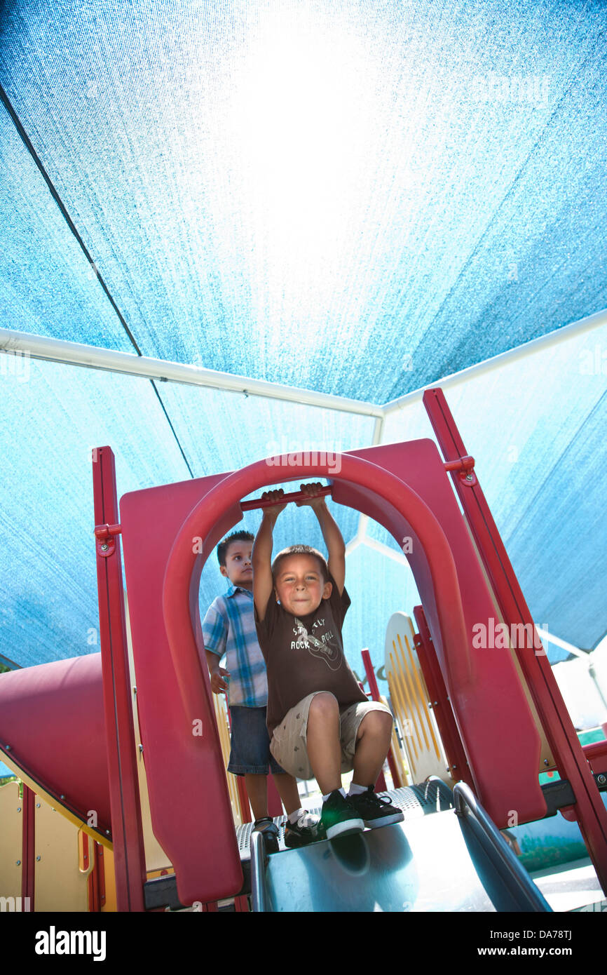 Bambini che giocano su un parco giochi slitta ispanica caucasico asain Foto Stock