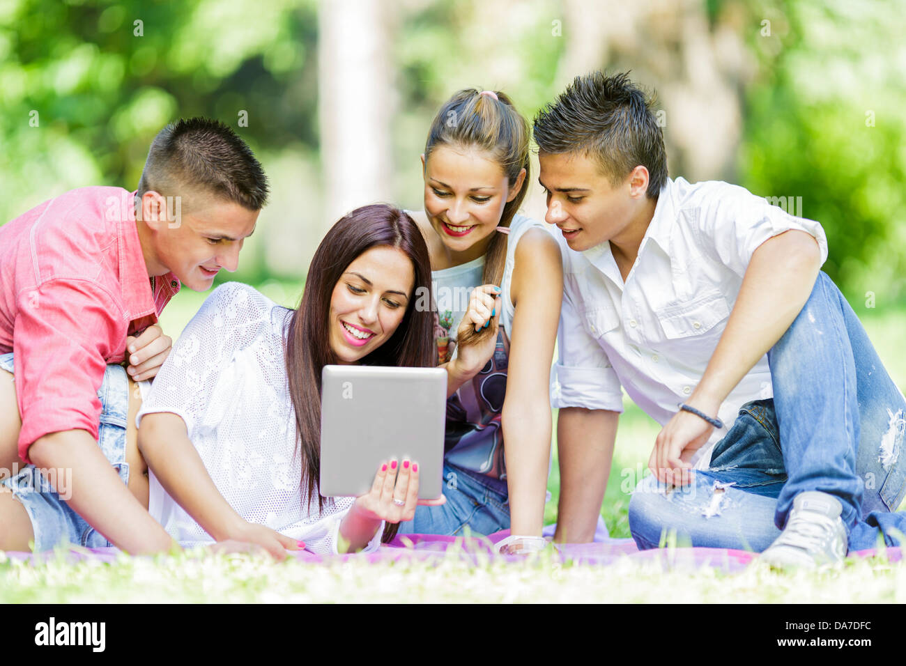 Gli adolescenti nel parco con la compressa Foto Stock