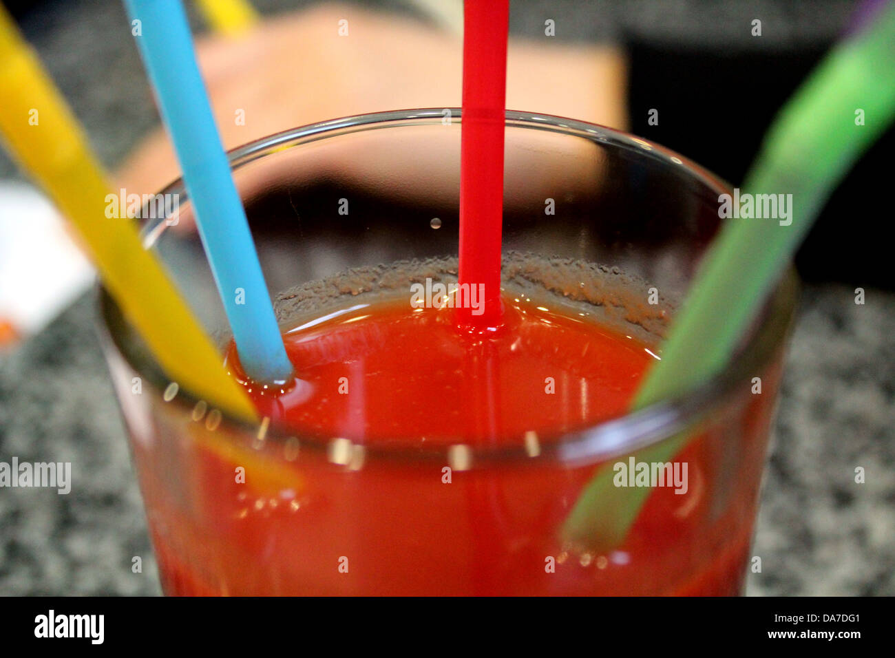 Immagine del bicchiere di succo di pomodoro con multi-tubuli colorati Foto Stock