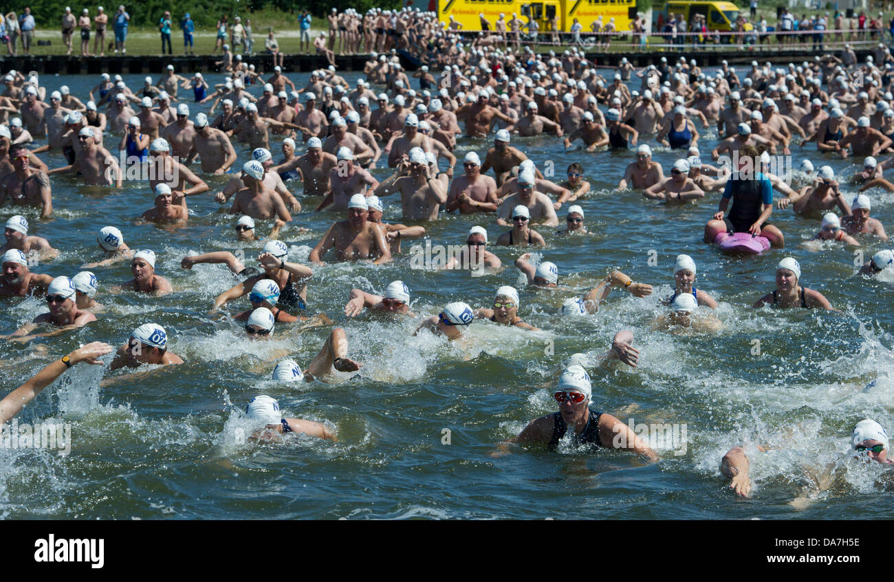 1.000 nuotatori andare in acqua all'inizio del 49th International 'Sundschwimmen' nuoto la concorrenza di Altefähr sull isola Ruegen a Stralsund attraversando il Strelasund (audio) in Stralsund, Germania, 06 luglio 2013. I partecipanti hanno a disposizione per coprire 2.135 metri in acqua a una temperatura di 19 gradi centigradi. La manifestazione tradizionale risale al 1837. Foto: Stefan Sauer Foto Stock