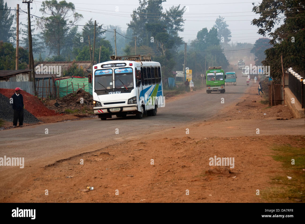 Un uomo in attesa di un autobus su una strada polverosa, Jimma, Etiopia Foto Stock