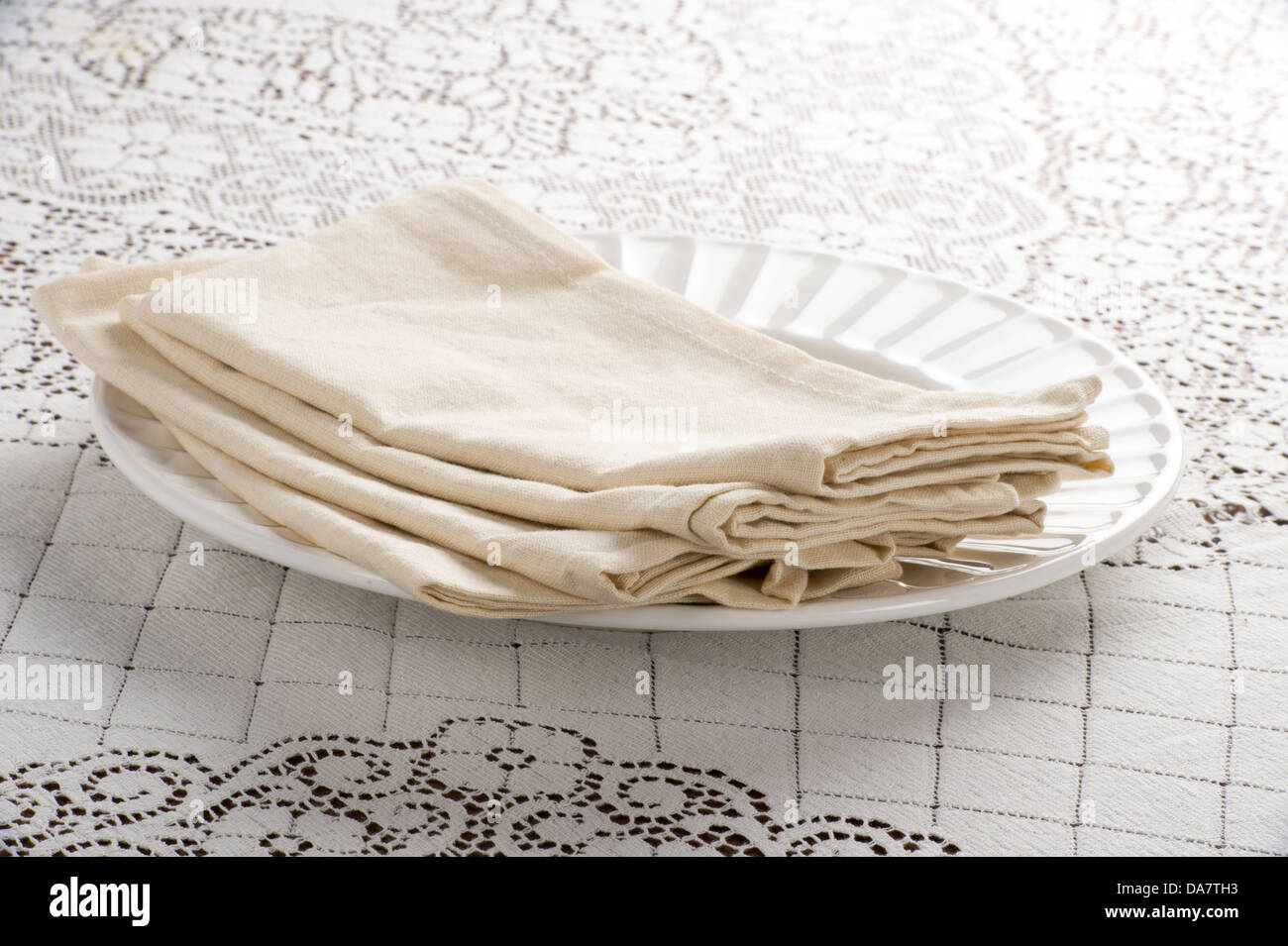 Pila di tovaglioli di stoffa sulla piastra bianca situato sulla tovaglia di  pizzo Foto stock - Alamy
