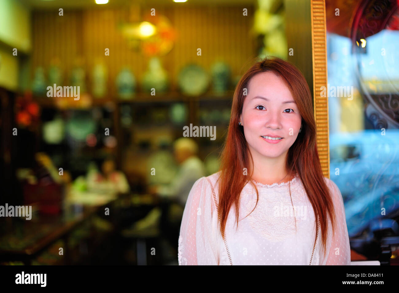 Ragazza cinese presso la sua azienda in Chinatown di Singapore Foto Stock