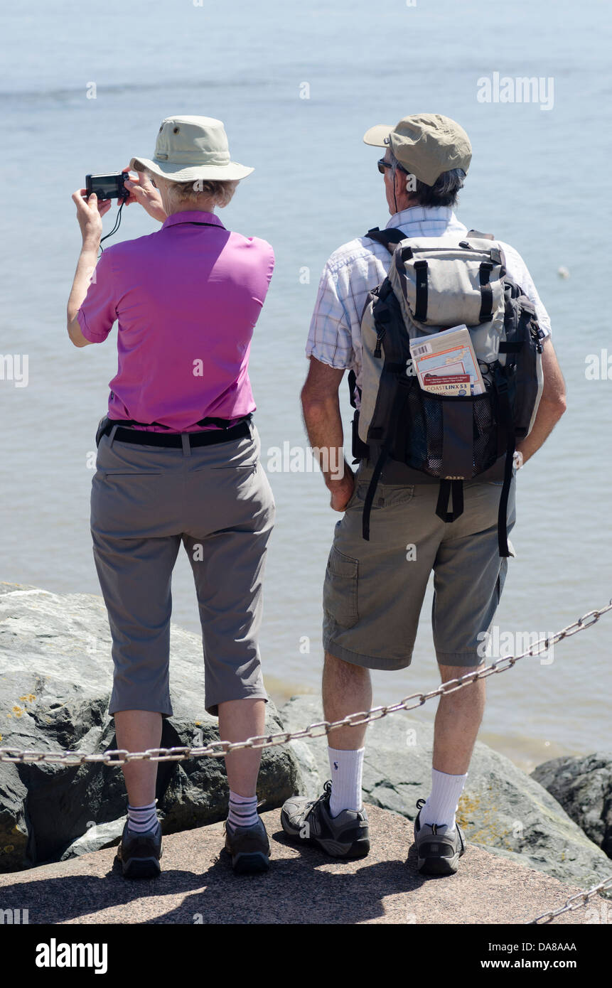 Due turisti, l uomo e la donna,vestito in escursionismo marcia la visualizzazione di siti a Lyme Regis Dorset. Foto Stock