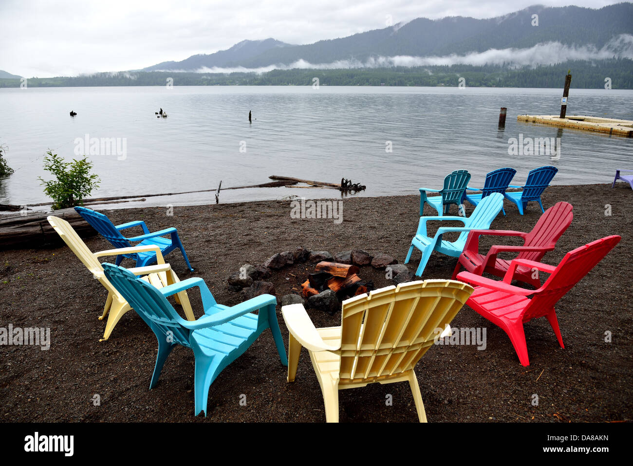 Colorate sedie da spiaggia sul lago Quinault shore aggiunto alcuni colori per una grigia giornata di pioggia. Il Parco nazionale di Olympic, Washington, Stati Uniti d'America. Foto Stock
