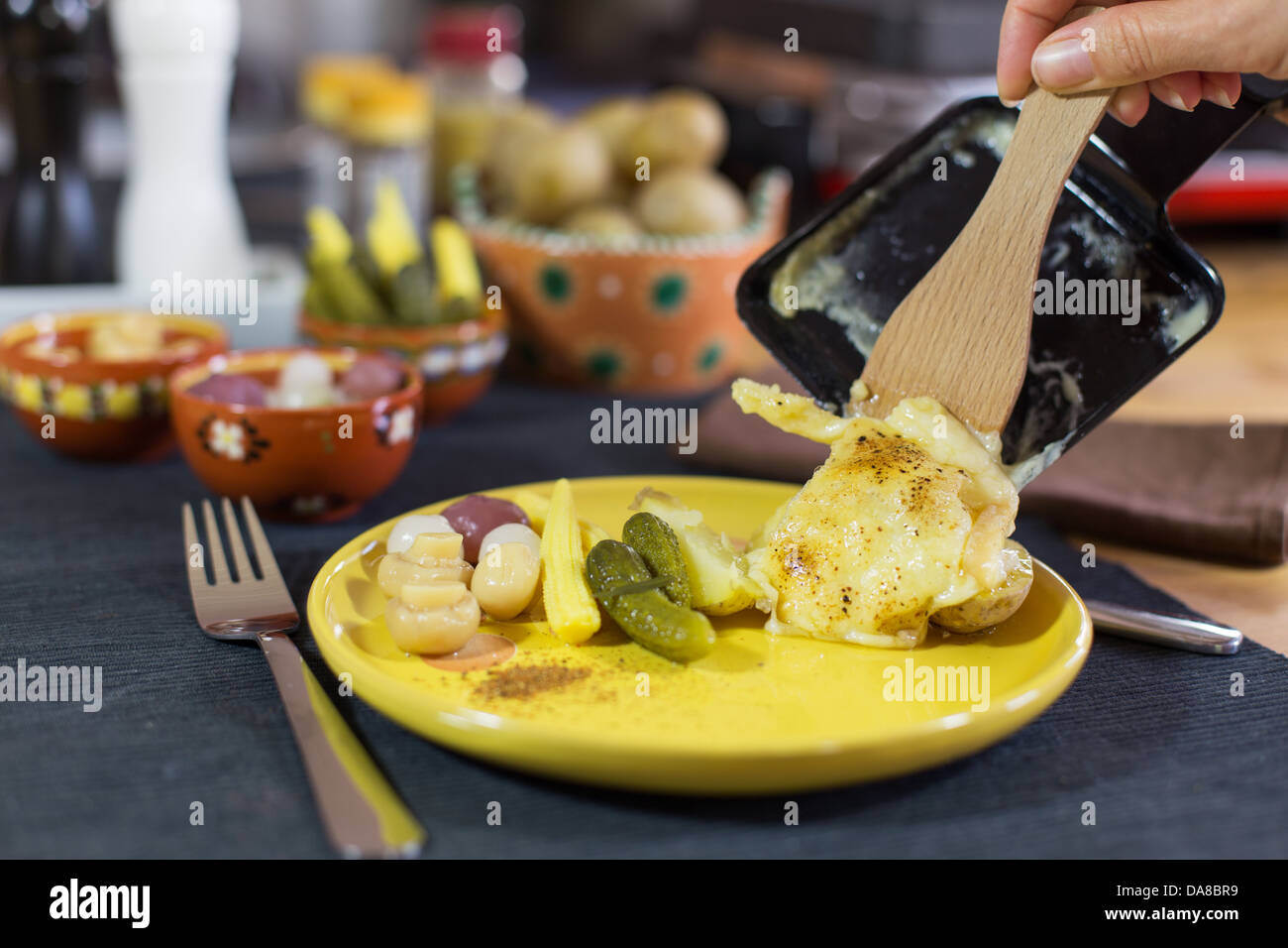 La raclette, specialità tradizionale di grigliate di giallo formaggio, patate e sottaceti. Foto Stock