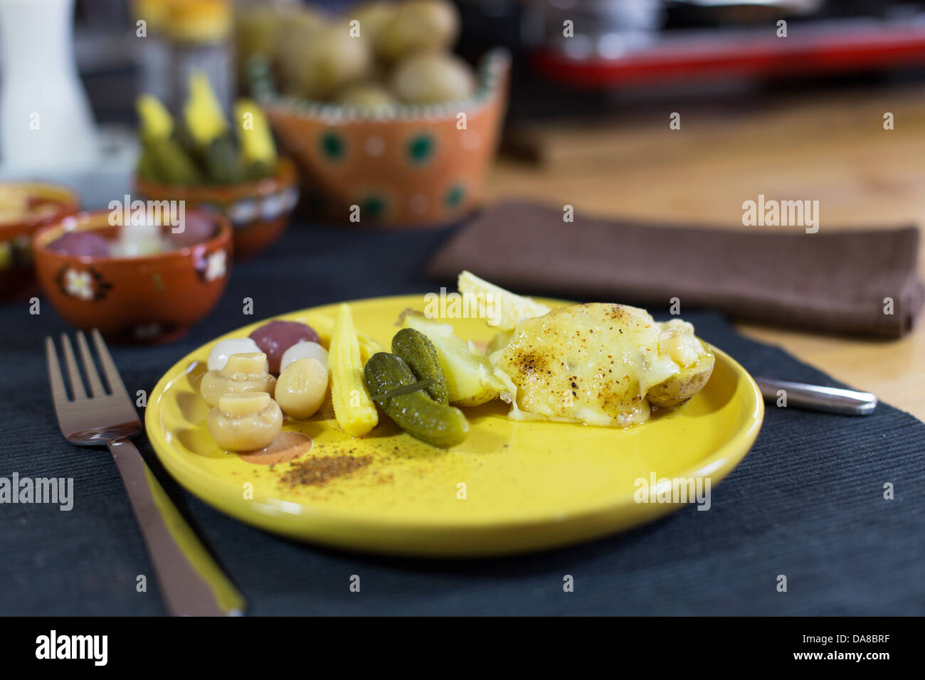 La raclette, specialità tradizionale di grigliate di giallo formaggio, patate e sottaceti. Foto Stock