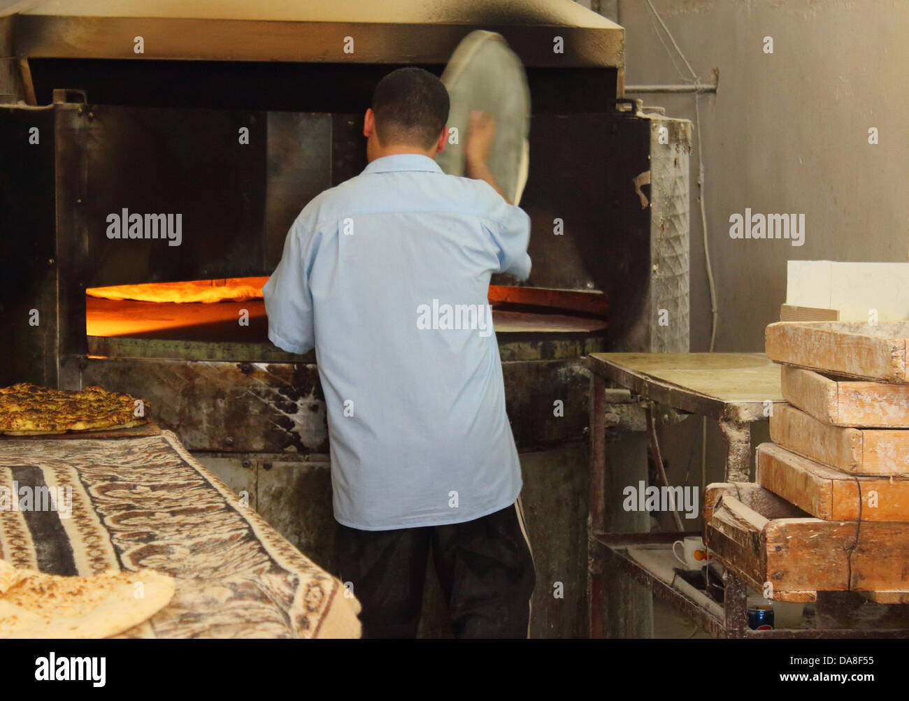 Arab baker rendendo pane arabo . Foto Stock