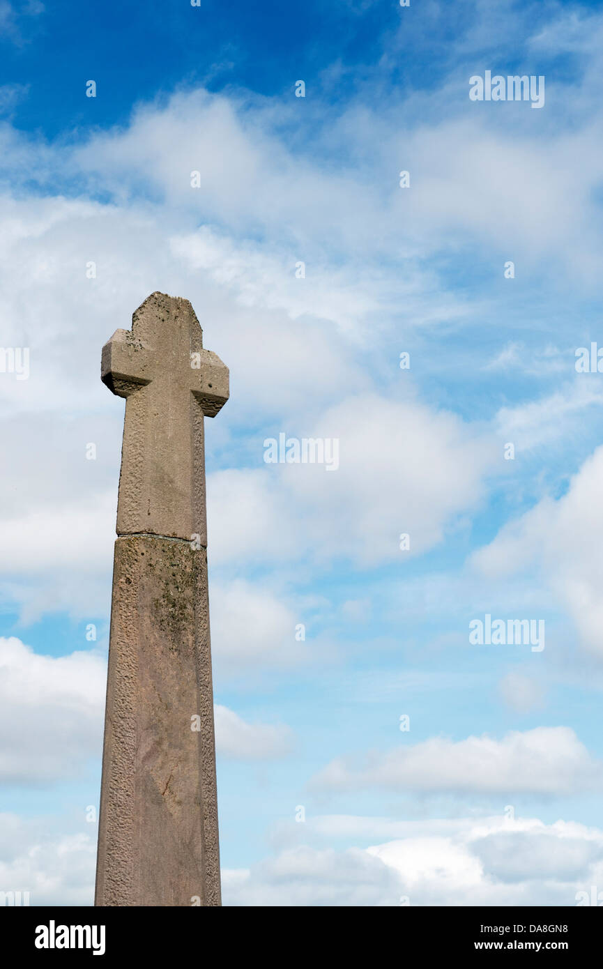 Memorial cross contro blu cielo nuvoloso sull Isola Santa Lindisfarne, Northumberland, Inghilterra Foto Stock