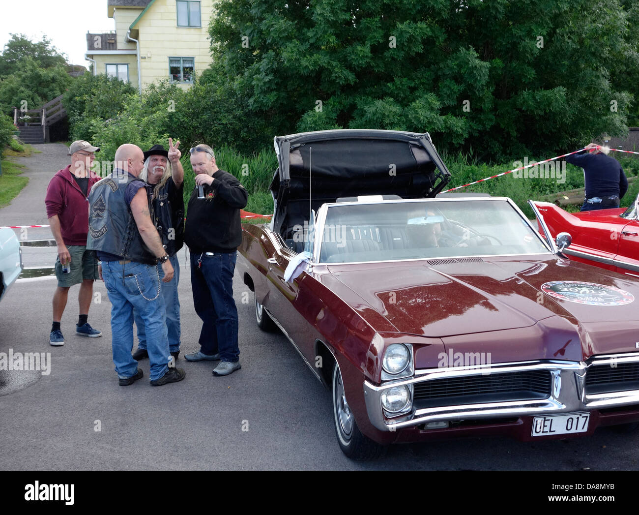 "Raggare" stile rockabilly uomini di mezza età stare vicino al retro automobile Pontiac BONNEVILLE (licenza svedese piastra) Foto Stock