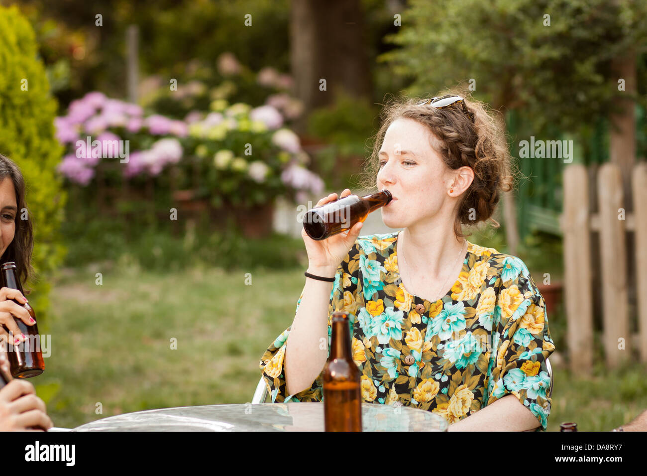 Bella giovane donna di bere birra in una terrazza all'aperto Foto Stock