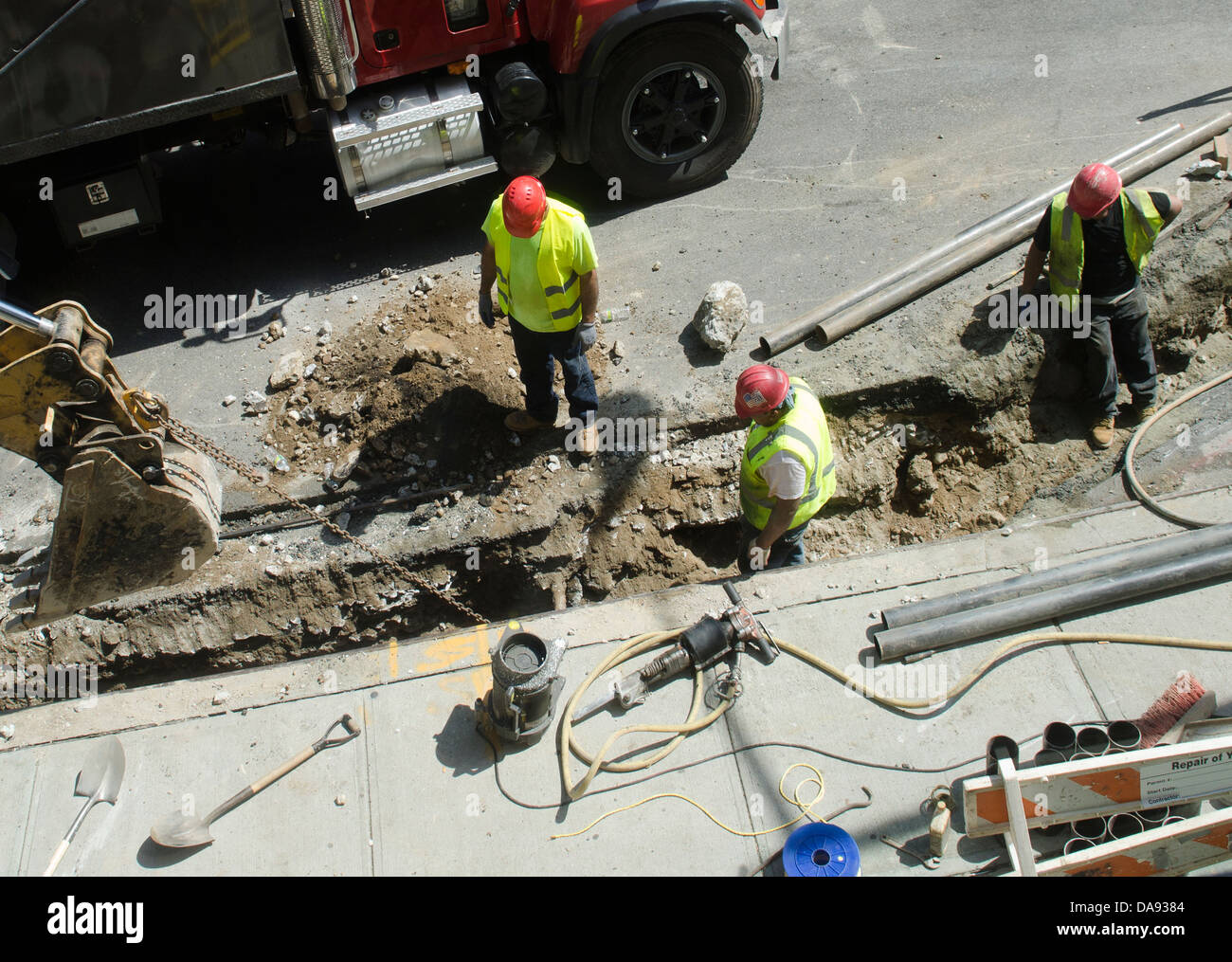 Aziende di servizi di pubblica utilità degli uomini sul sito di riparazione in strada Foto Stock