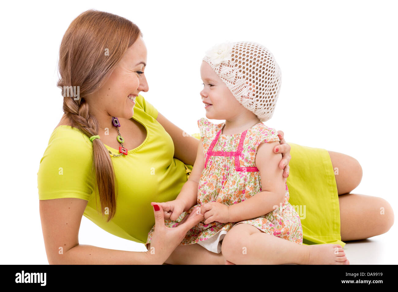 Felice madre e bambina giacente sul pavimento bianco e sorridente Foto Stock