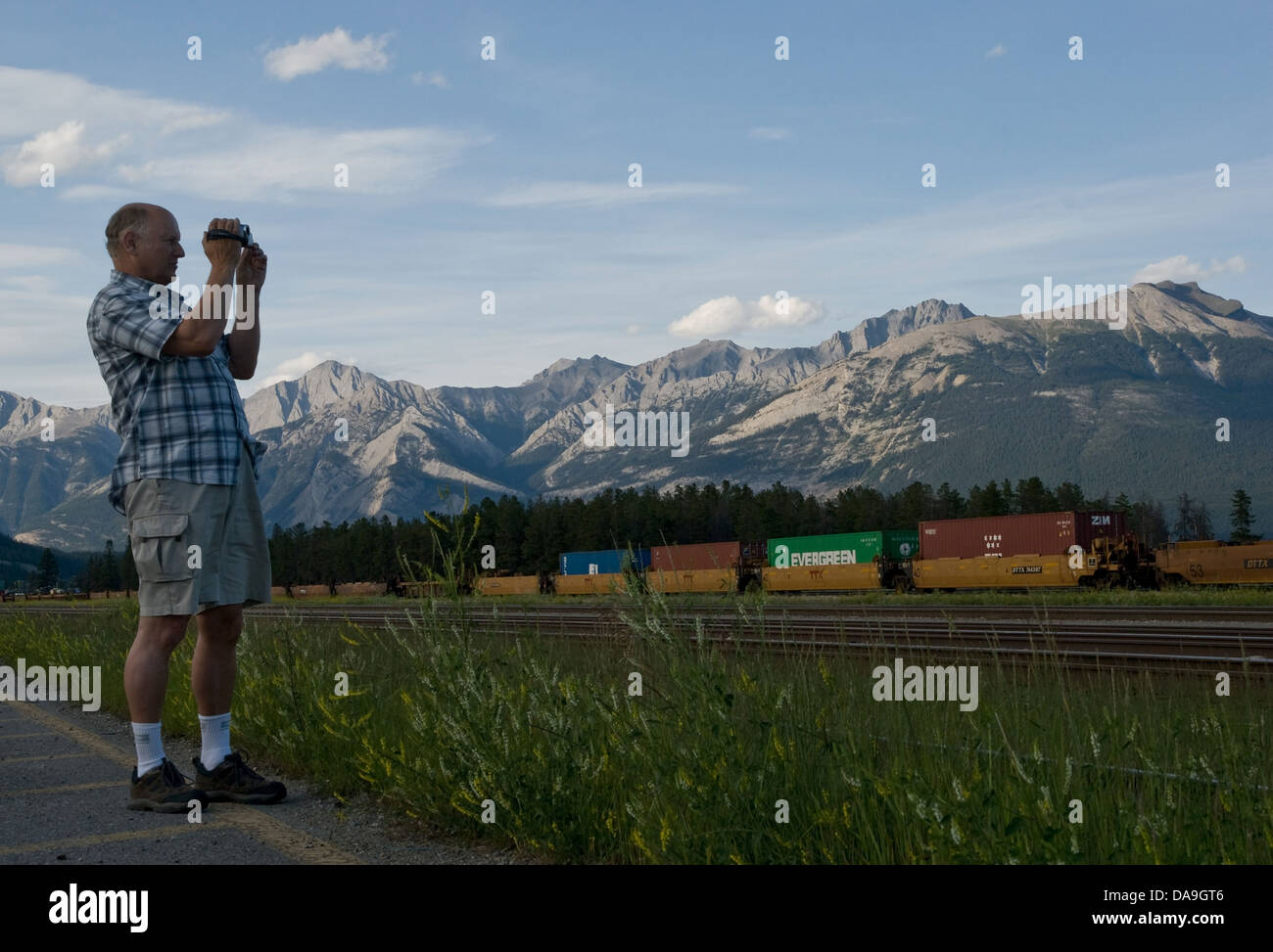 Un trainspotter filmare un treno che va passato. Foto Stock