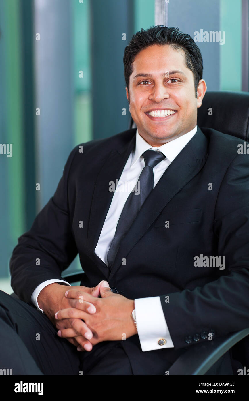 Allegro Indian business uomo seduto in un ufficio moderno Foto Stock