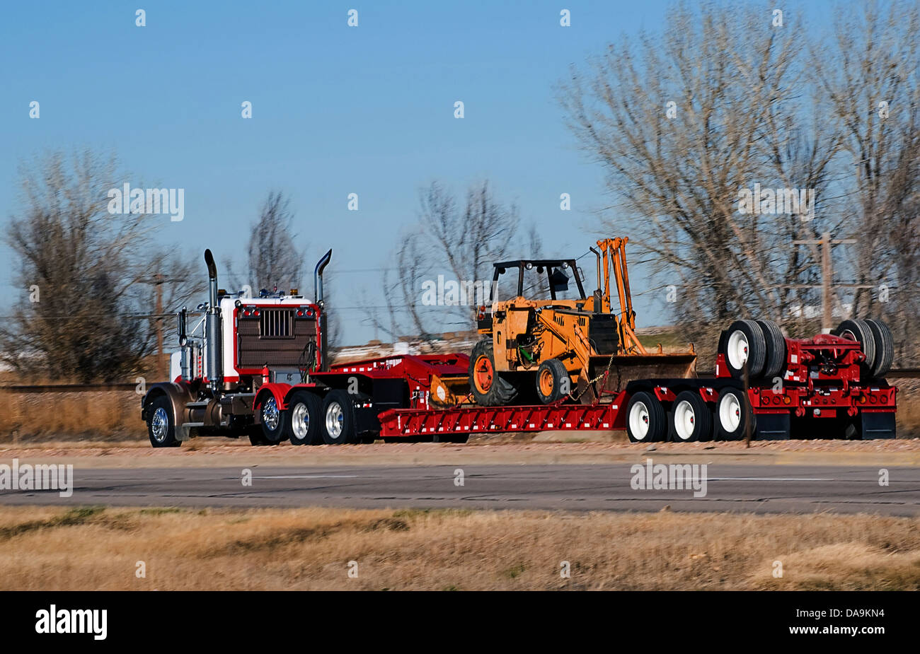 Semi-carrello pipeline di trasporto Attrezzatura di posa su una goccia-deck rimorchio. Foto Stock