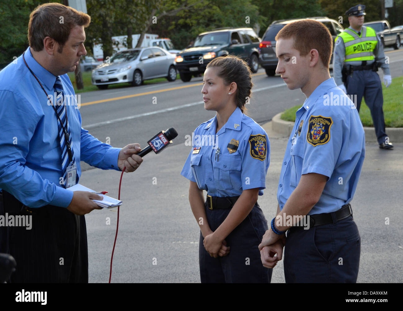 Un TV reorter interviste due cadetti di polizia al funerale di un poliziotto ucciso nella linea del dazio Beltsville, Maryland Foto Stock