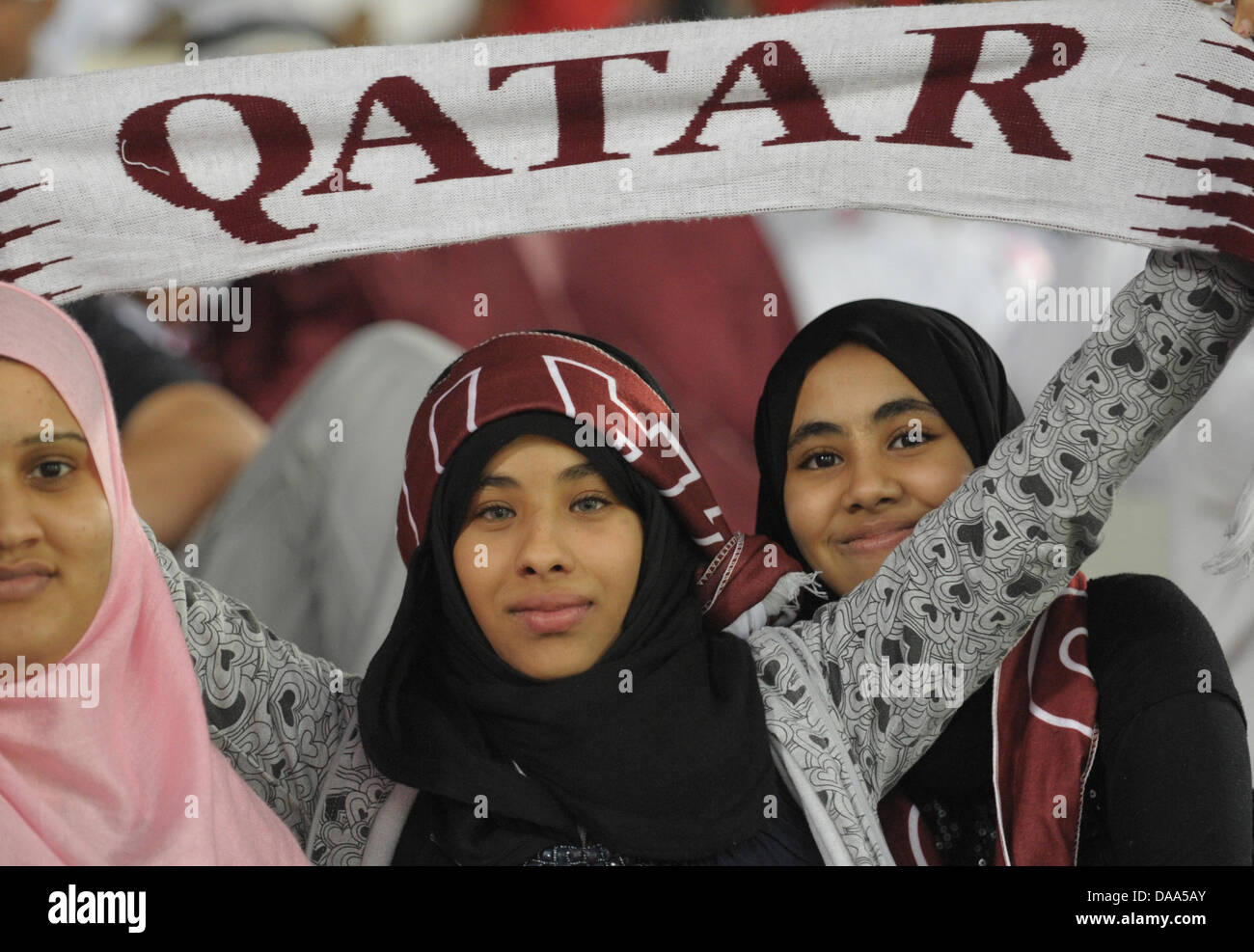 Giovane femmina ventole sudanesi del Qatar National Soccer team pone durante la partita di apertura per l'Asia Cup 2011 Al Khalifa Stadium di Doha, in Qatar, 7 gennaio 2011. Il team di hosting Qatar perso contro Usbekistan da 0-2. L'Asia Cup 2011 avviene in Qatar da 7 fino al 29 gennaio 2011. Foto: Andreas Gebert Foto Stock