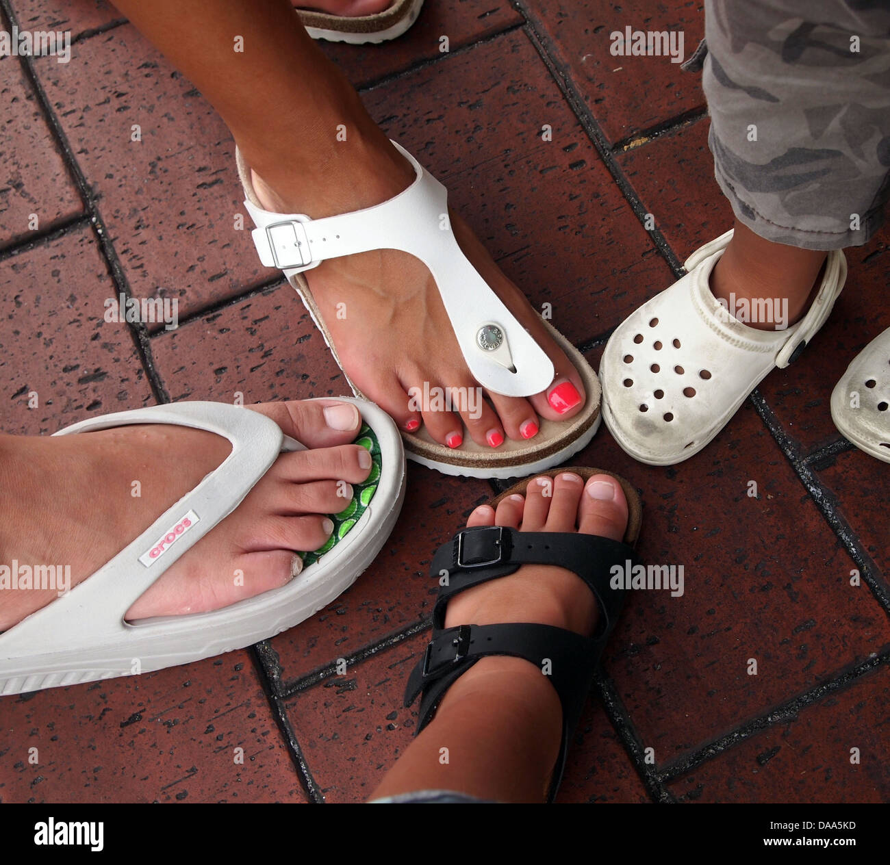 Si tratta di una foto vista dalla cima delle persone confrontando le dimensioni dei loro piedi o lo stile del proprio paio di scarpe. Foto Stock