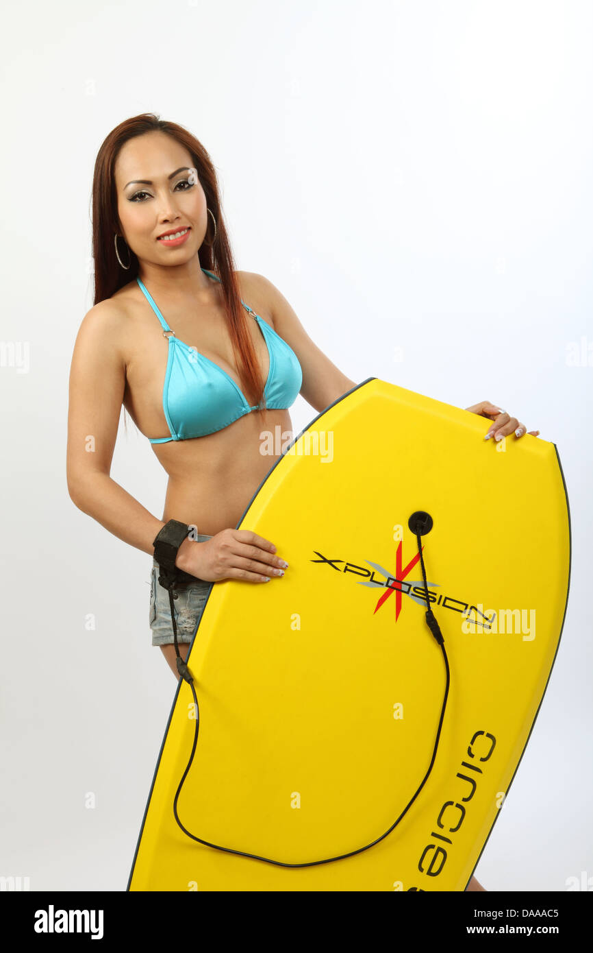 Bella giovane donna asiatica in un bikini tenendo un corpo giallo board Foto Stock