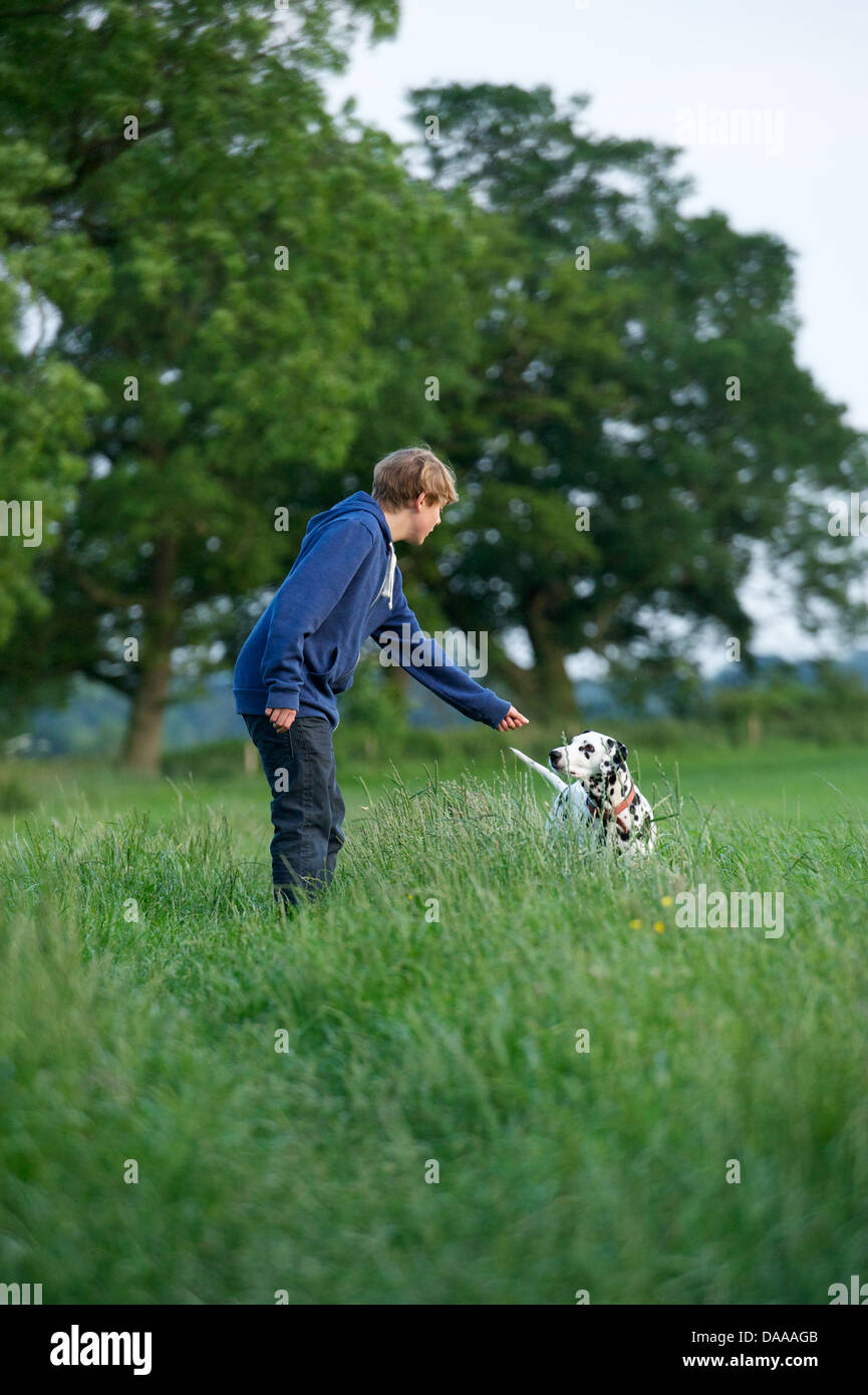 Un giovane ragazzo con il suo gatto cane dalmata. Foto Stock
