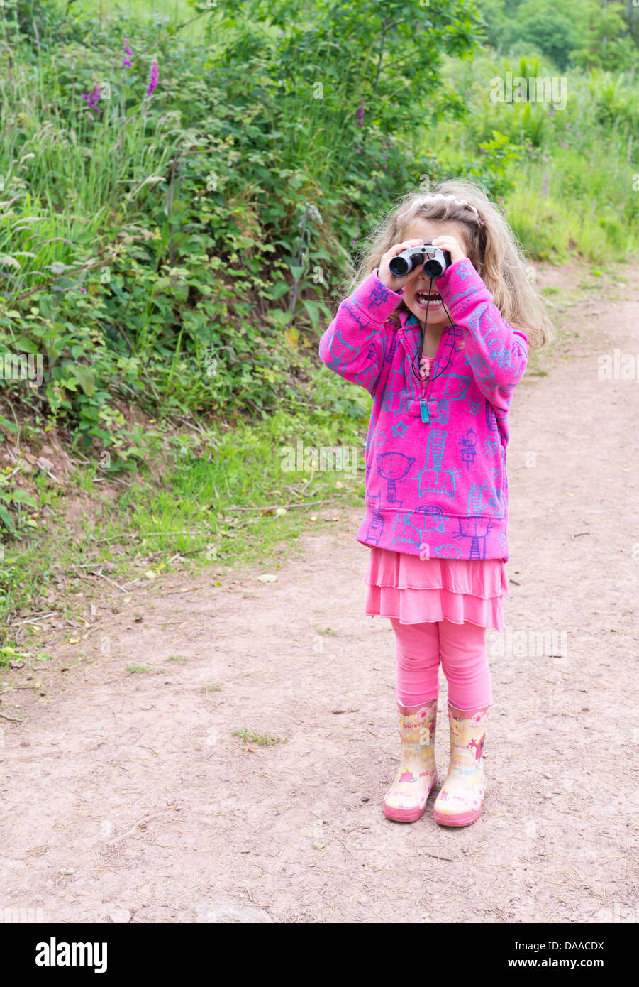 4 anno vecchia ragazza di esplorare al di fuori con il binocolo Foto Stock