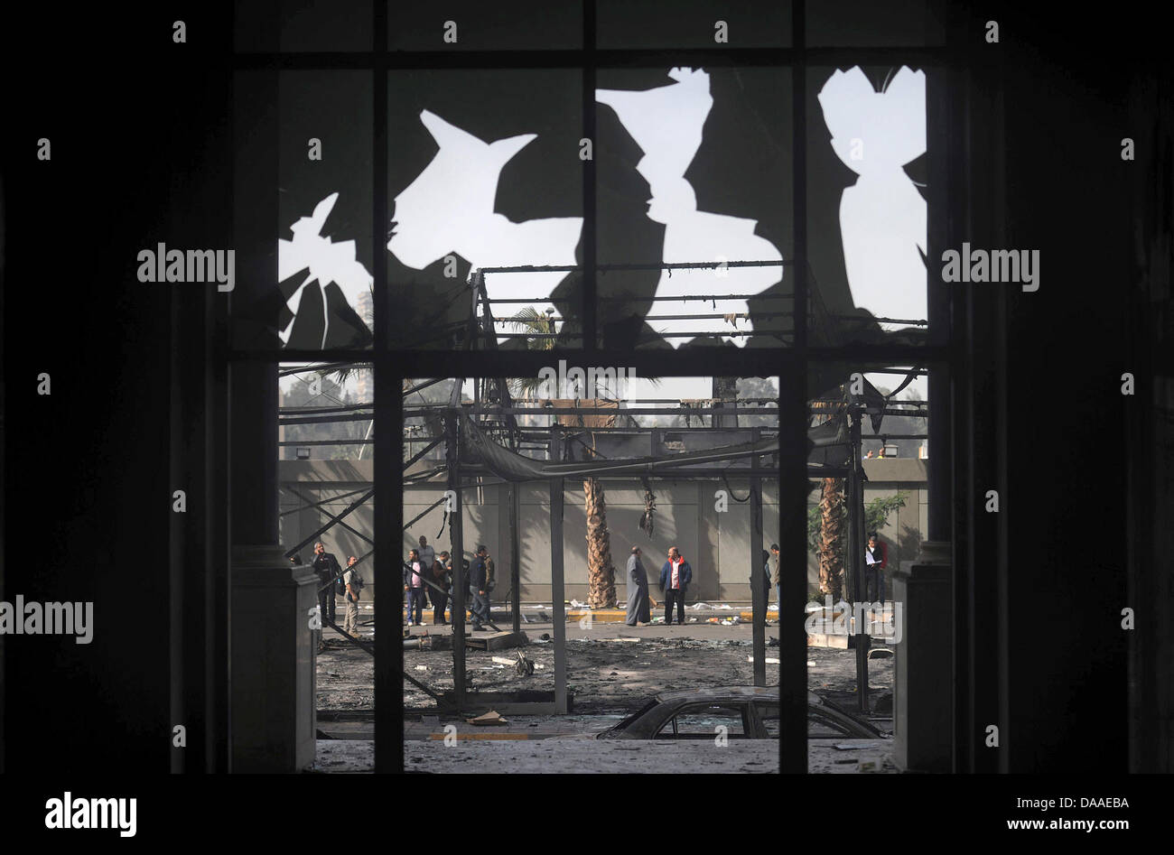 Curiosi di visitare il saccheggiato e bruciato la sede del "National Democratic Party", il partito di governo d'Egitto il Presidente egiziano Hosni Mubarak al Cairo, Egitto, 29 gennaio 2011. Ampia diffusione saccheggi e disordini hanno continuato in Egitto il capitale questo sabato. Le testimonianze oculari ha raccontato del saccheggio di negozi in corso, mentre in due distretti del Cairo, le stazioni di polizia espugnò Foto Stock