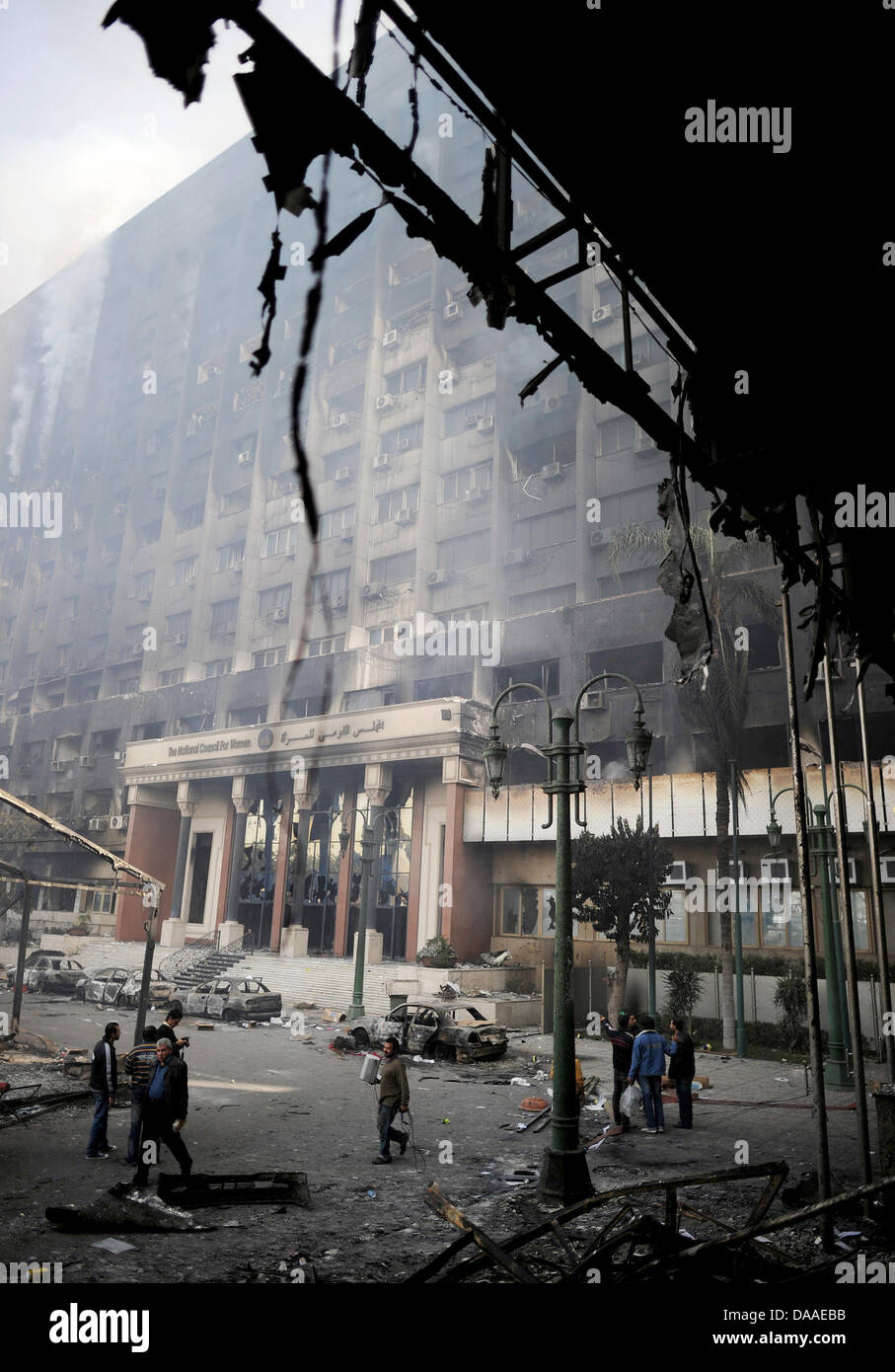 Curiosi di visitare il saccheggiato e bruciato la sede del "National Democratic Party", il partito di governo d'Egitto il Presidente egiziano Hosni Mubarak al Cairo, Egitto, 29 gennaio 2011. Ampia diffusione saccheggi e disordini hanno continuato in Egitto il capitale questo sabato. Le testimonianze oculari ha raccontato del saccheggio di negozi in corso, mentre in due distretti del Cairo, le stazioni di polizia espugnò Foto Stock