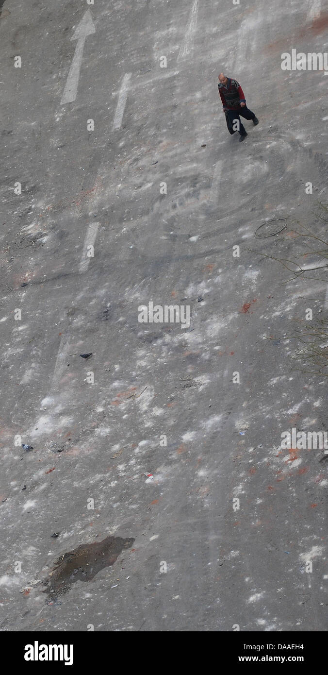 Eine Mann geht am Sonntag (30.01.2011) in der Nähe des Tharir-Platzes in Kairo über eine leere, besudelte Straße. In der Nacht zum Sonntag kam es zu wieder zu Ausschreitungen und Plünderungen. In den Wohnvierteln der ägyptischen Hauptstadt, wo das Militär nicht in Stellung gegangen guerra, organisierten sich Bewohner in Bürgerwehren, um sich gegen Plünderer zu schützen. Foto: Annibale Foto Stock