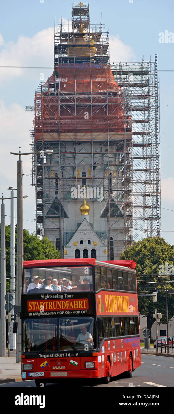 Un autobus turistico rigidi passato San Alexei della Russia della chiesa Memoriale di Lipsia, in Germania, 09 luglio 2013. La chiesa è in fase di ristrutturazione per un costo di circa un milione di euors e dovrebbe essere completata entro l'autunno 2013 per il duecentesimo anniversario della battaglia delle nazioni. La Chiesa commemora i circa 22.000 soldati russi che erano stati uccisi nella battaglia. Foto: HENDRIK SCHMIDT Foto Stock
