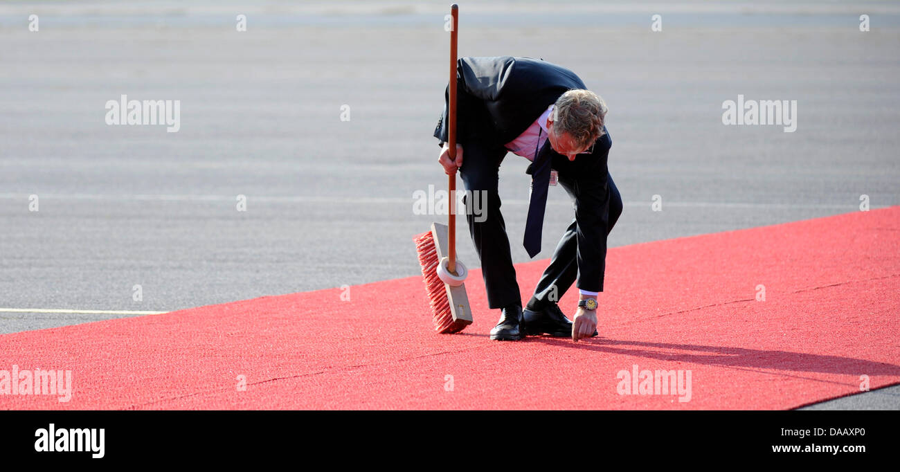 Un uomo che pulisce il tappeto rosso prima dell arrivo di Papa Benedetto XVI all aeroporto Tegel di Berlino, 22 settembre 2011. Il capo della Chiesa Cattolica Romana si è recato in visita in Germania da 22-25 settembre 2011. Foto: Maurizio Gambarini dpa/lbn +++(c) dpa - Bildfunk+++ Foto Stock