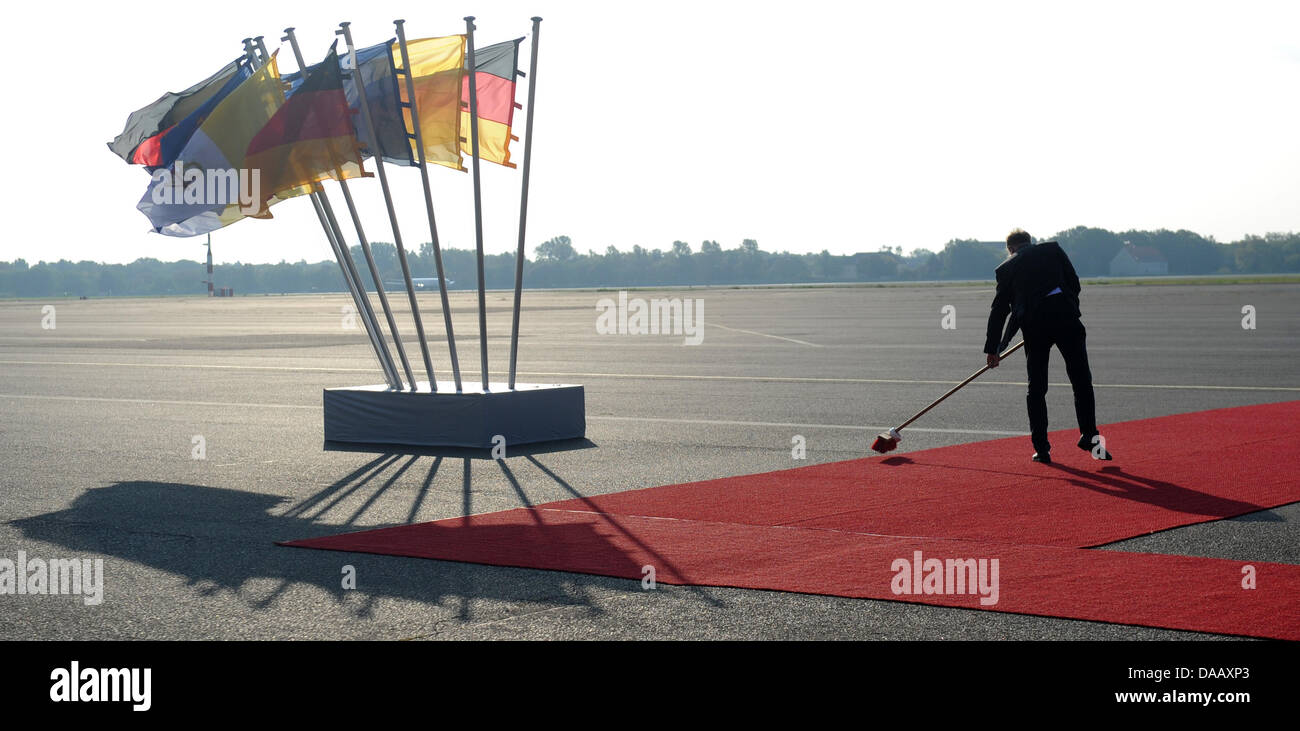 Un uomo che pulisce il tappeto rosso prima dell arrivo di Papa Benedetto XVI all aeroporto Tegel di Berlino, 22 settembre 2011. Il capo della Chiesa Cattolica Romana si è recato in visita in Germania da 22-25 settembre 2011. Foto: Maurizio Gambarini dpa/lbn Foto Stock
