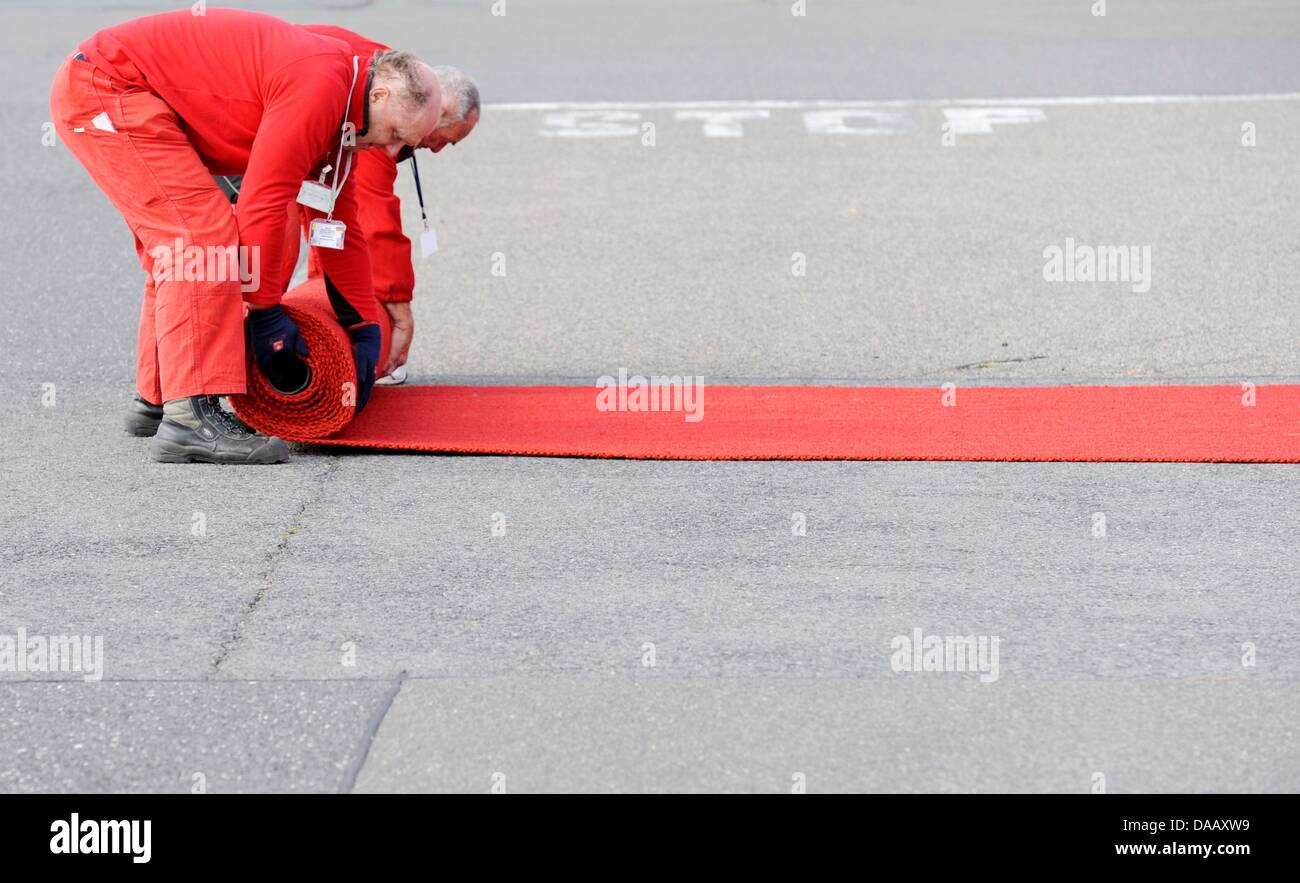 Lavoratori tenere lontano il rosso Capet per sul Papa Benedetto XVI dopo il suo arrivo in aeroporto Tegel di Berlino, Germania, 22 settembre 2011. Il capo della Chiesa Cattolica Romana si è recato in visita in Germania da 22-25 settembre 2011. Foto: Maurizio Gambarini dpa/lbn Foto Stock