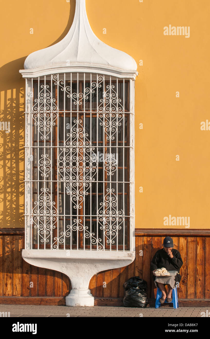 Ornati in ferro battuto e vetro donna street architettura del venditore in Trujillo, Perú. Foto Stock
