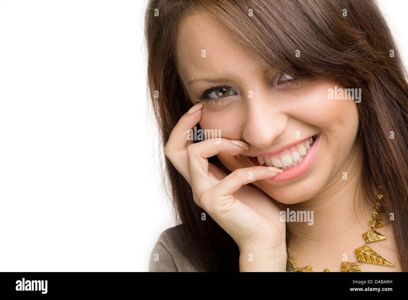 Sorriso toothy da una ragazza con la mano sulla bocca Foto Stock