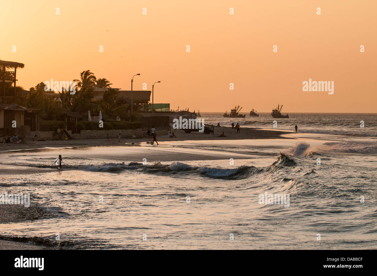 Surfisti con tavole da surf surf al tramonto sulla spiaggia di mancora, Perù. Foto Stock