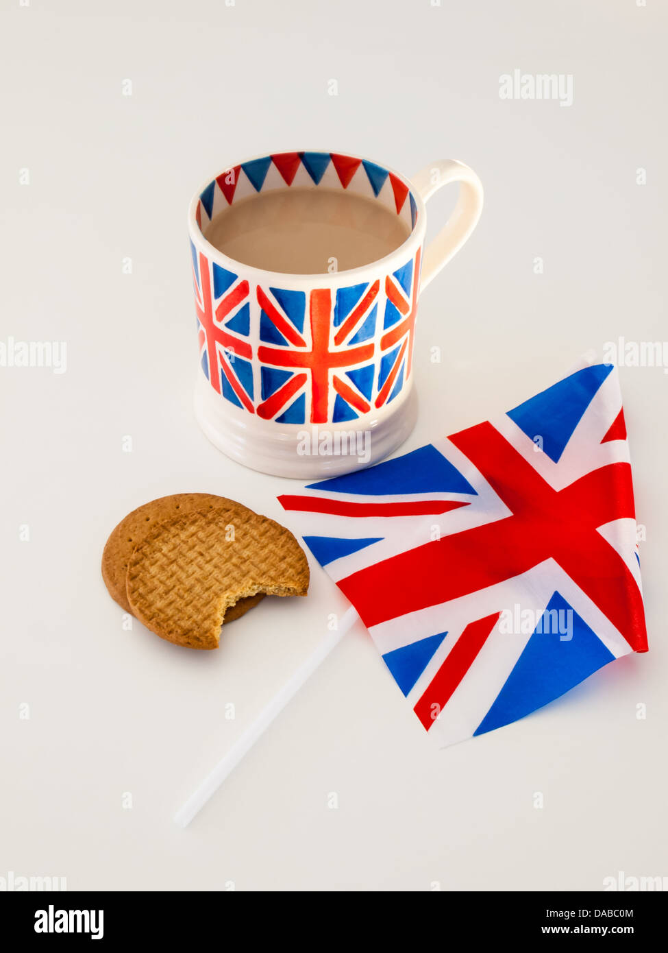 Una tazza di latte il tè inglese in un britannica union jack mug con biscotti digestivi e una bandiera britannica Foto Stock