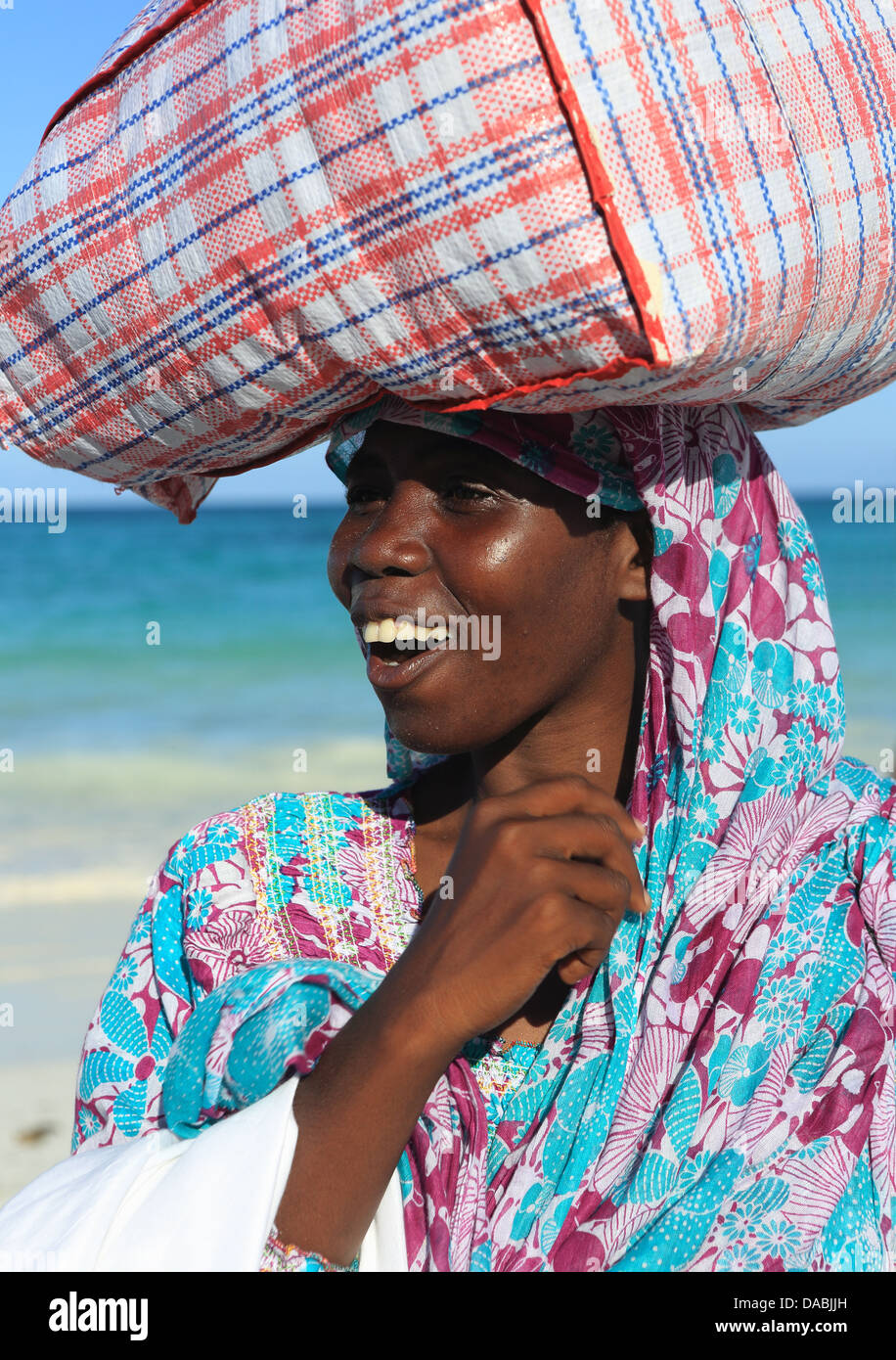 Donna pacchetto portante sulla testa, Zanzibar, Tanzania, Africa orientale, Africa Foto Stock