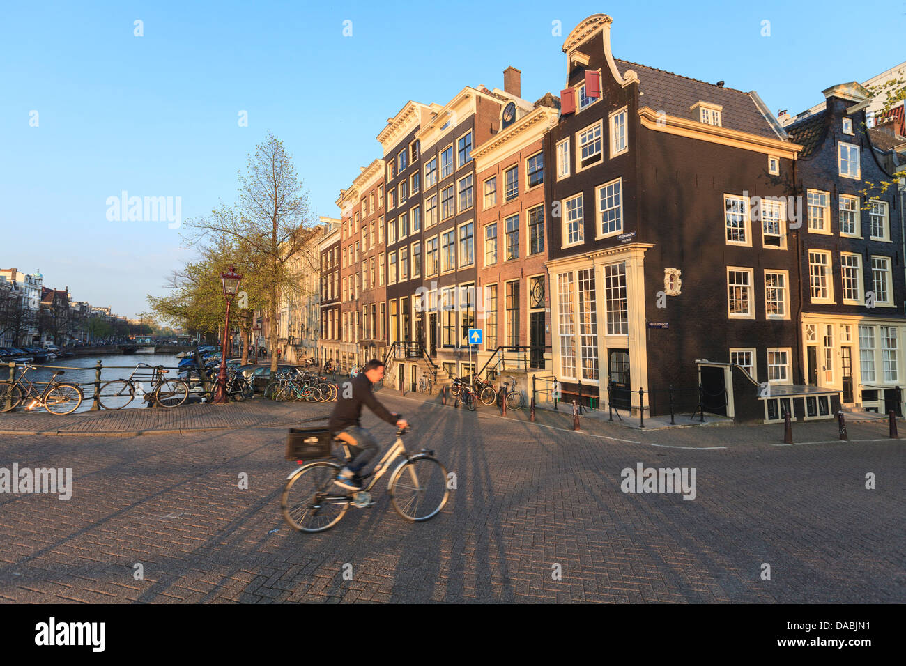 Ciclista attraversando un ponte sul canale Keizersgracht, Amsterdam, Paesi Bassi, Europa Foto Stock