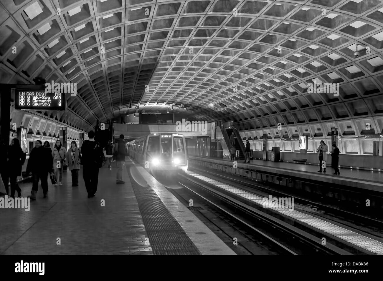 La metropolitana treno passa attraverso una stazione della metropolitana a Washington D.C. Pendolari attendere sulla piattaforma per esso. Foto Stock